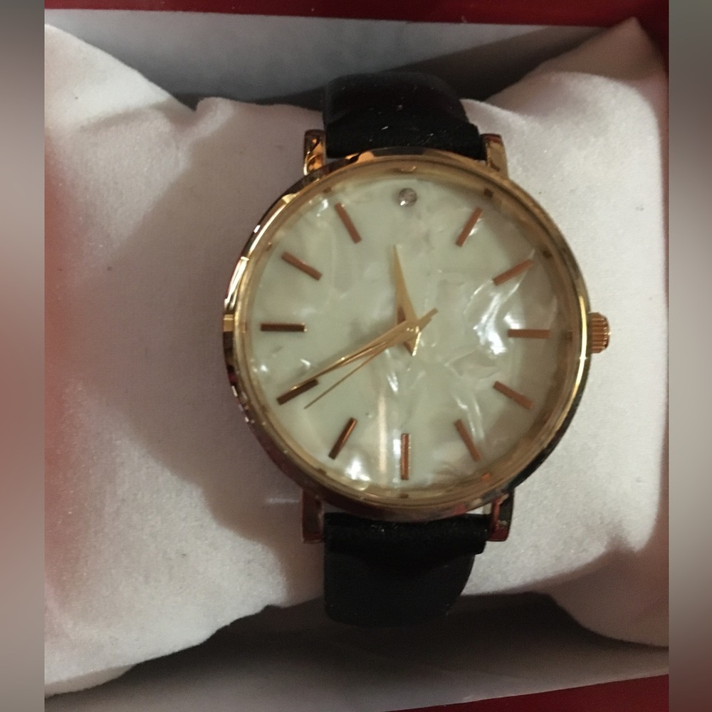 Women’s watch with mother of pearl face, gold casing, and black band